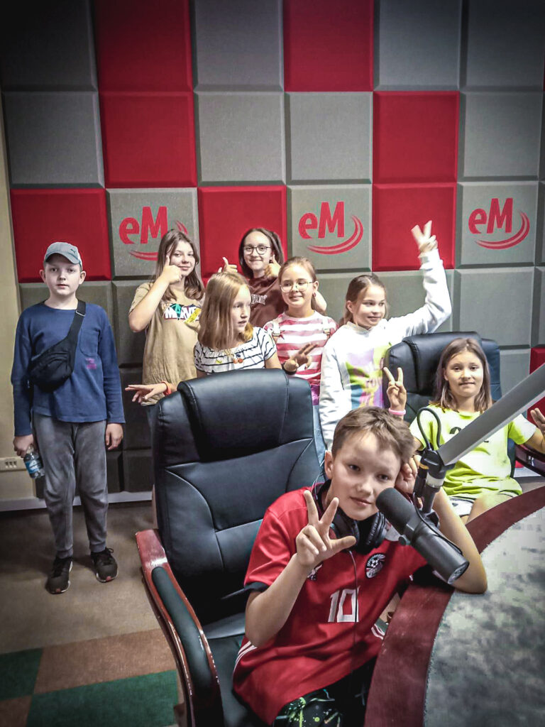 Zdjęcie. Grupa dzieci w studiu radiowym Radia eM.