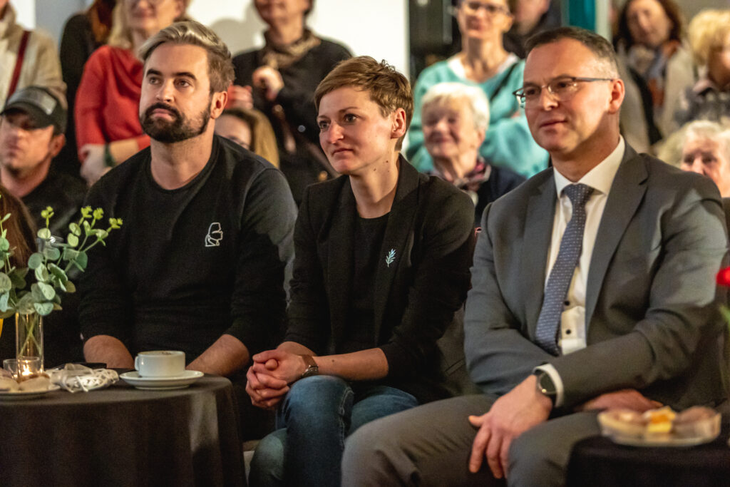 Zdjęcie. Widzowie spotkania z Anną Dymną. Od lewej: wicedyrektor KCK Artur Wijata, wiceprezydentka Kielc Agata Wojda i radny Arkadiusz Ślipkowski.