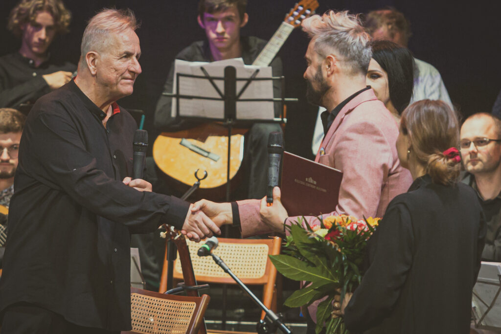 Zdjęcie. Wicedyrektor KCK Artur Wijata gratuluje jubileuszu Jerzemu Pikorowi.