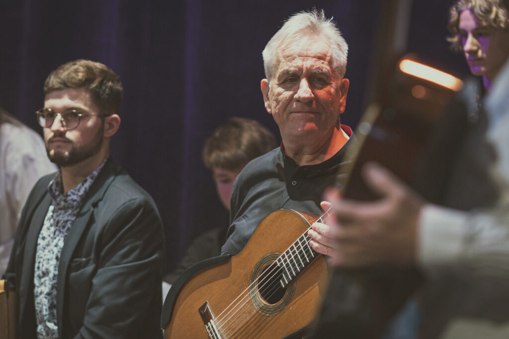 Zdjęcie. Jerzy Pikor z gitarą obok inni muzycy.