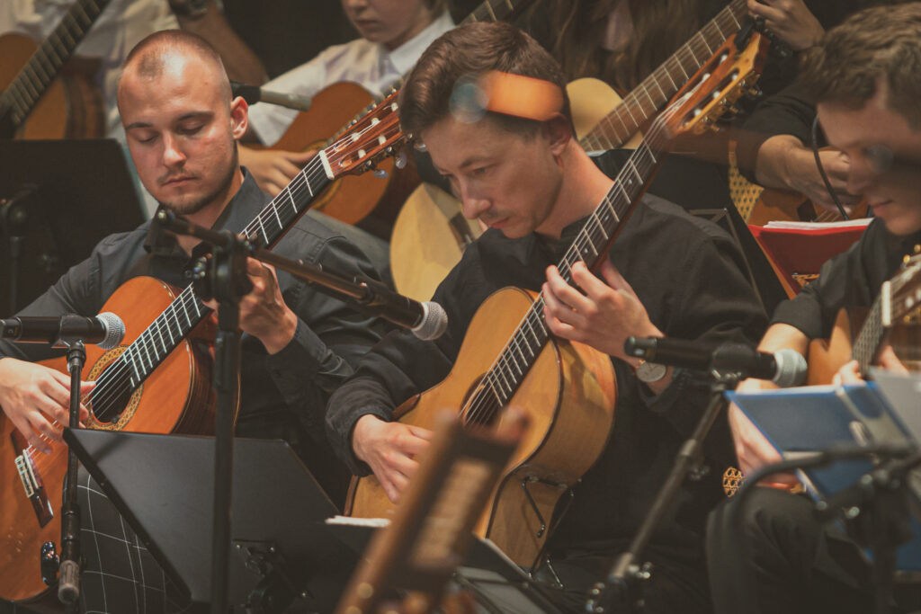 Zdjęcie. Gitarzyści podczas grania.