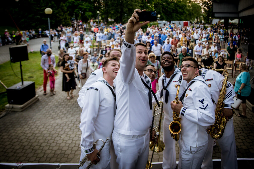 Zdjęcie. Zespół TOPSIDE Band robi sobie zdjęcie selfie na tle widowni ich koncertu na Letniej Scenie KCK.